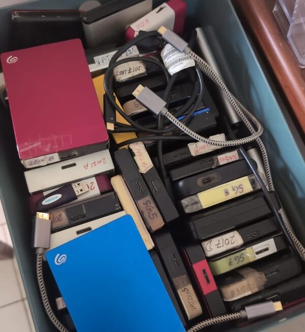 A box full of labeled external hard drives